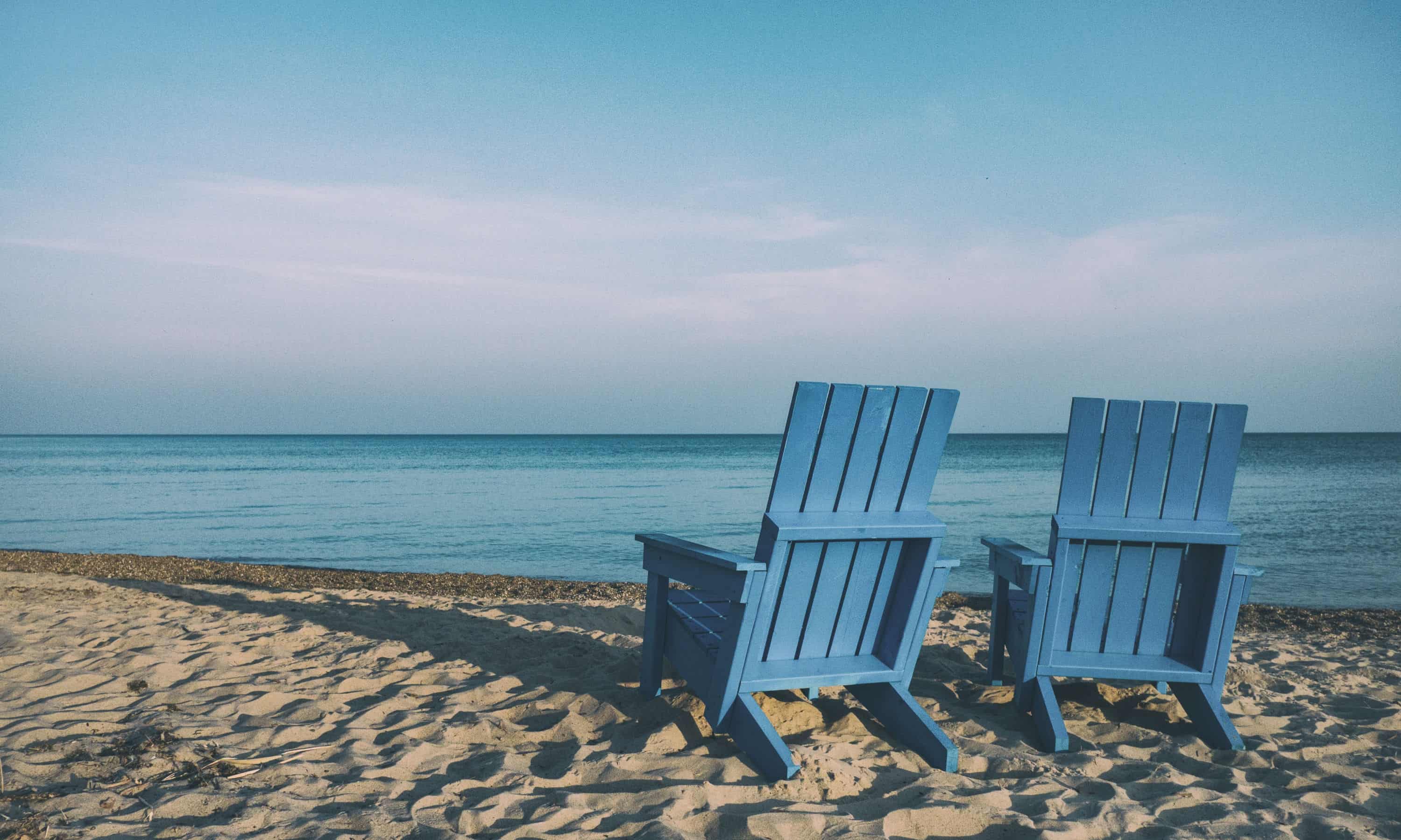 Two blue chairs on the beach